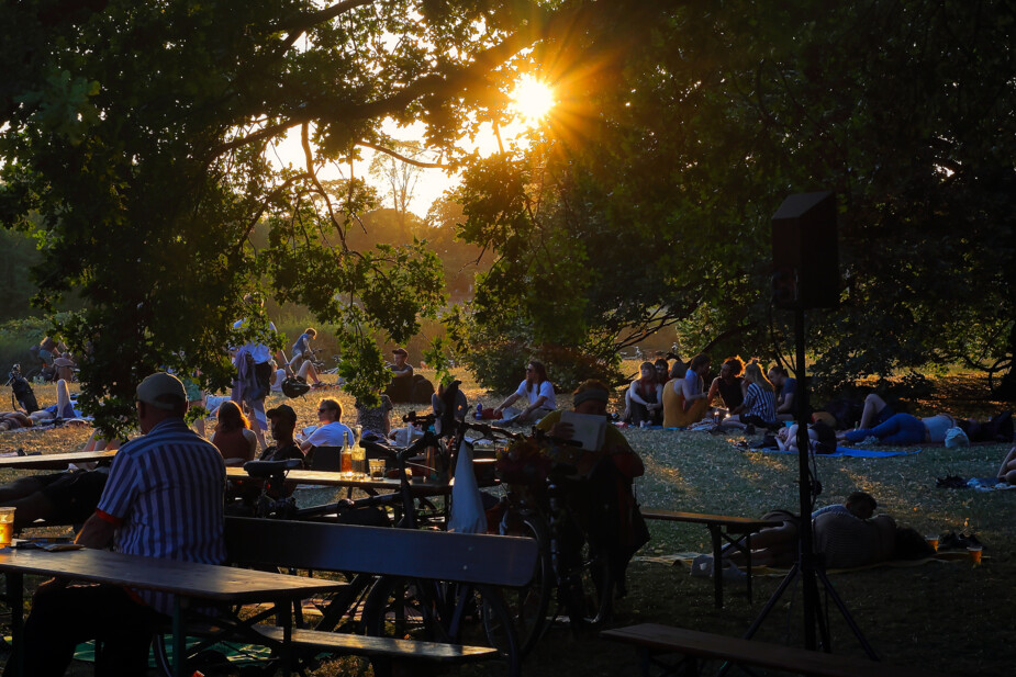 Besucher*innen des Hörspielsommers entspannen auf Bierbänken